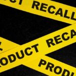Yellow product recall tape on black background.