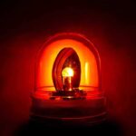 Red emergency light glowing in darkness.