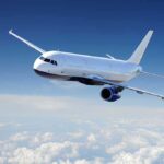 Airplane flying above fluffy white clouds sky