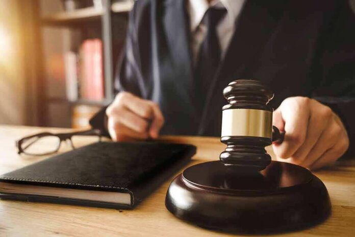 1035925210 featured image Gavel judges hand glasses and book on desk