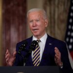 Energy Policy Dilemma: Balancing Ambition and Accountability in Biden’s White House Man speaking at podium with microphones indoors