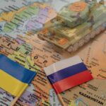 Putin Suggests Surprising 30-Day Ceasefire to Encourage Ukrainian Peace Talks Toy tank on map with Ukraine and Russia flags