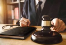 Gavel on table with glasses and notebook