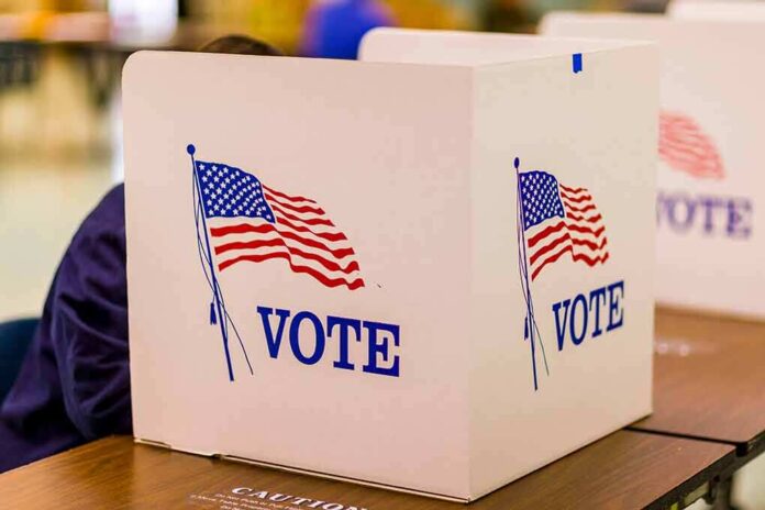 1046168668 featured image Voting booth with American flag and "VOTE" text.