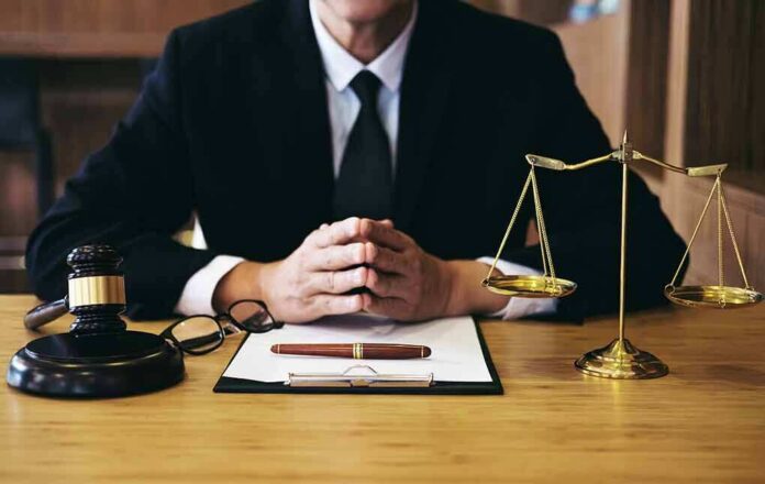 1092414422 featured image Person in suit with gavel and scales of justice