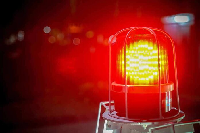 1157118232 featured image Flashing red warning light with blurred background.