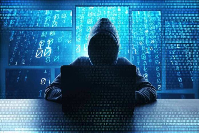 1198362232 featured image Hacker in hoodie typing on laptop with binary code.