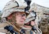 Soldiers in combat gear looking focused and attentive
