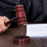 Judges hand holding a gavel near documents