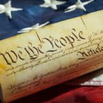 US Constitution on American flag background.
