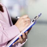 Oakland’s Political Unrest: Mayor’s Recall and Shocking Revelations Unraveling the City Person writing on a clipboard with a pen