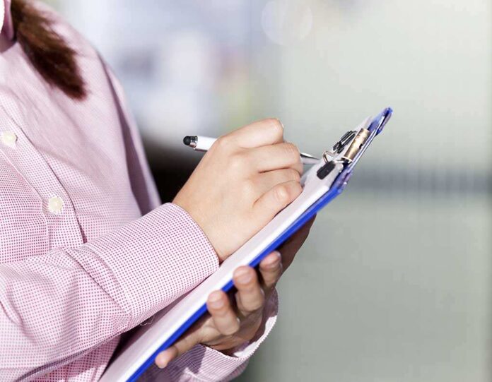 376166491 featured image Person writing on a clipboard with a pen