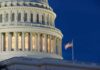 US Capitol building with American flag illuminated