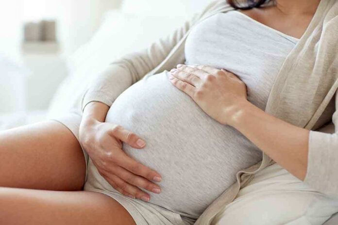 564114571 featured image Pregnant woman holding her belly, sitting comfortably.