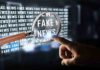 Magnifying glass highlights fake news text on screen