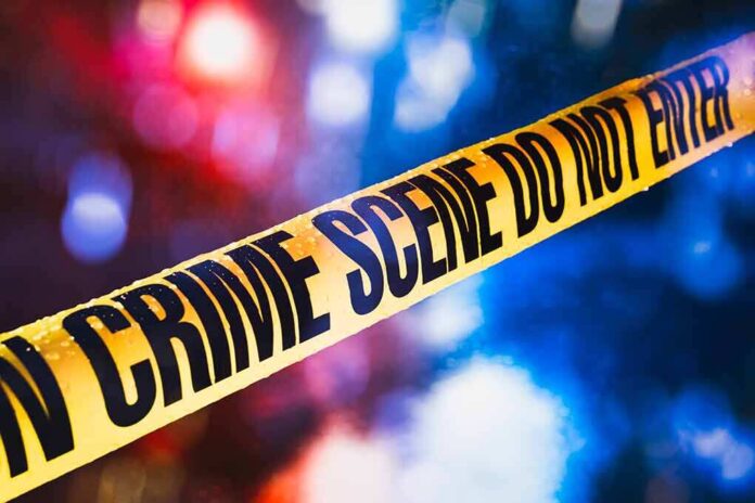 1019775253 featured image Yellow crime scene tape with blurred lights background