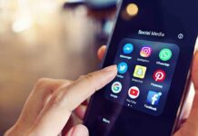 Finger tapping social media app icons on a smartphone.