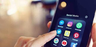 Finger tapping social media app icons on a smartphone.