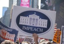 Protesters hold signs calling for impeachment