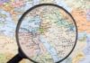 Magnifying glass focused on the Middle East map.