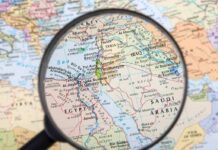 Magnifying glass focused on the Middle East map.