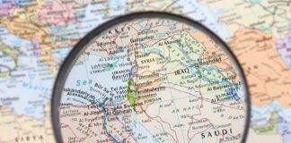 Magnifying glass focused on the Middle East map.