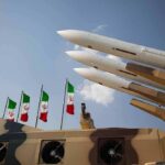 Missiles on launcher with flags in background sky