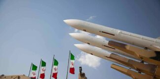 Missiles on launcher with flags in background sky