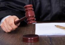 Judges hand holding a gavel near documents
