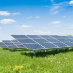 Shady Green Firms EXPOSED—Taxpayer Bill SKYROCKETS Solar panels in a grassy field under blue sky.