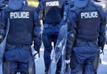 Police officers in riot gear with shields