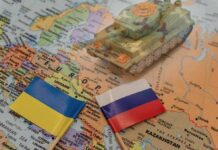 Toy tank on map with Ukraine and Russia flags