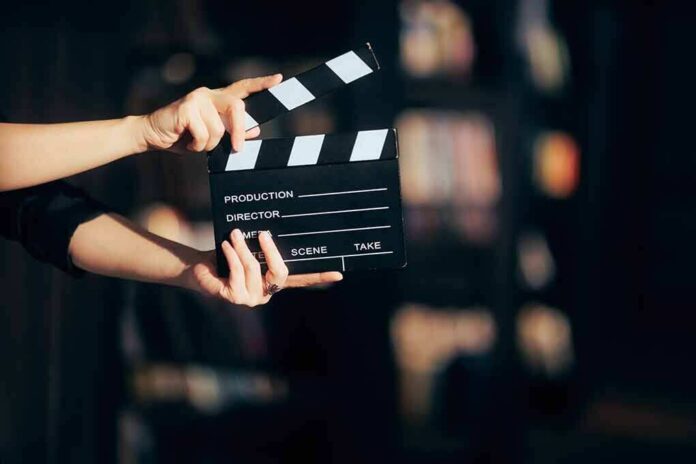 2128884842 featured image Hands holding a film clapperboard against a dark background