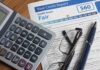 Calculator and glasses on credit report document
