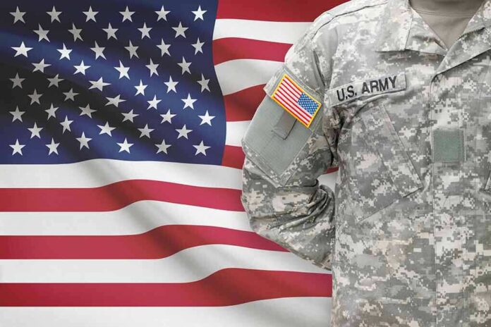 247938520 featured image Soldier in camouflage uniform standing before American flag
