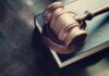 Wooden gavel resting on thick book