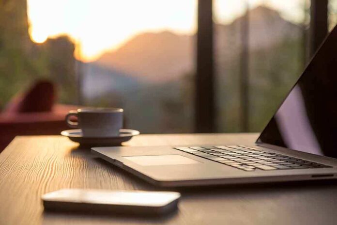 350692013 featured image Laptop, coffee cup, and phone on wooden table.