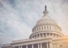 Capitol dome with American flag, under cloudy sky.