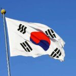 South Korean flag waving against clear blue sky.