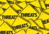 Yellow warning signs with the word THREATS