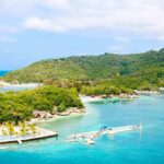 Tropical beach with dockstand lush green hill