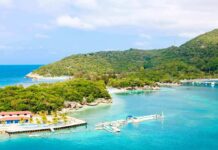 Tropical beach with dockstand lush green hill