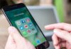 Person holding phone with social media app icons