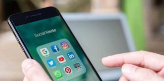 Person holding phone with social media app icons