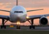 Airplane on runway during sunset with lights on