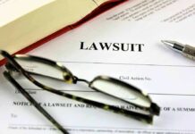 Lawsuit document with pen glasses and open book