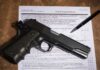 Gun and pen on firearm transaction form