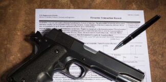 Gun and pen on firearm transaction form.
