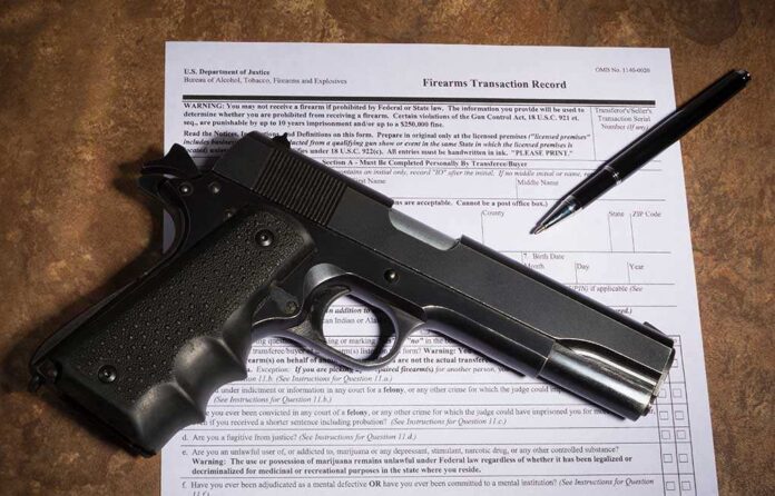 1026045637 featured image Gun and pen on firearm transaction form.