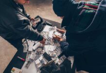 Two individuals handling stacks of money on a table
